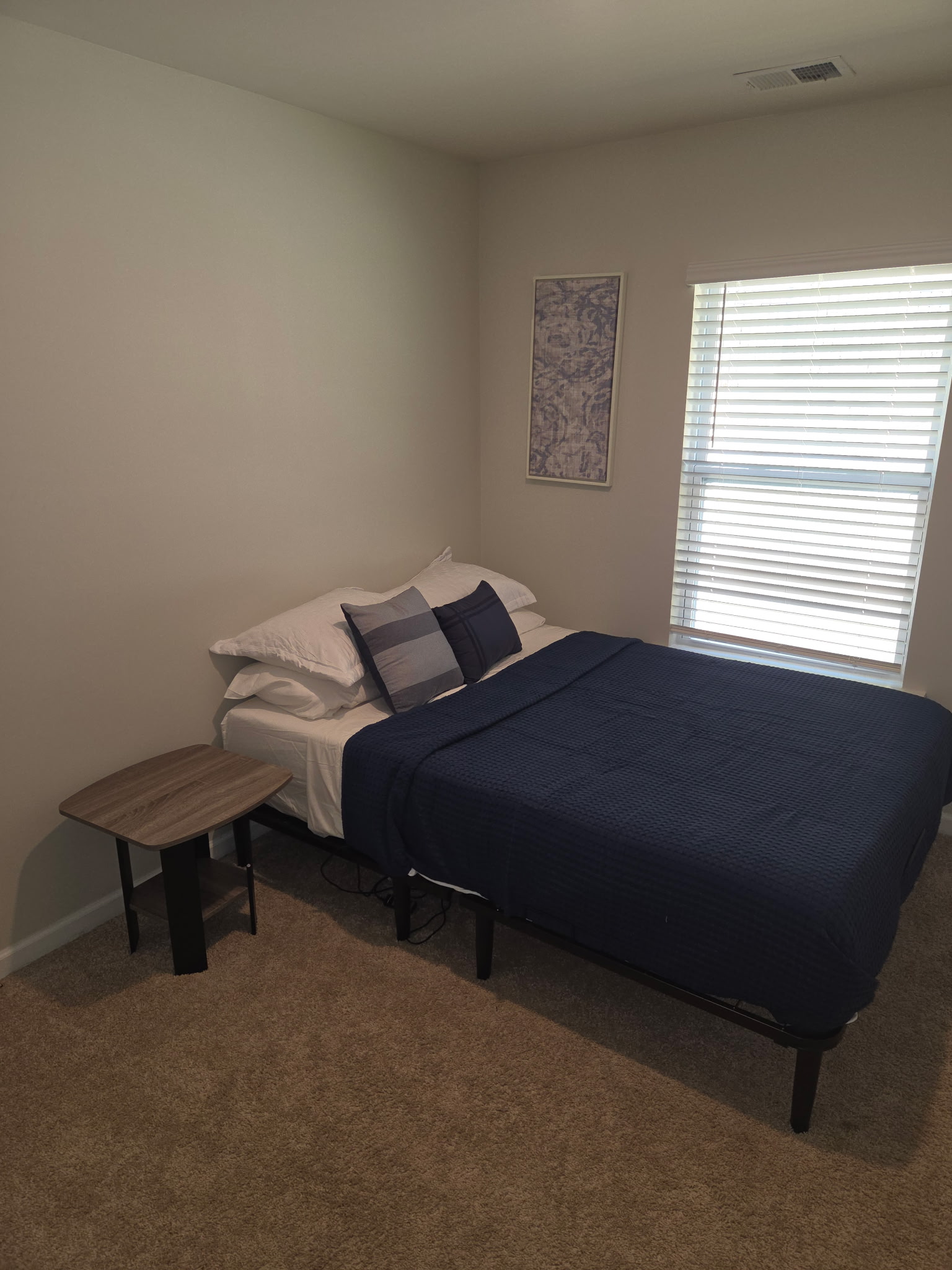 Bedroom with a navy bedspread and window
